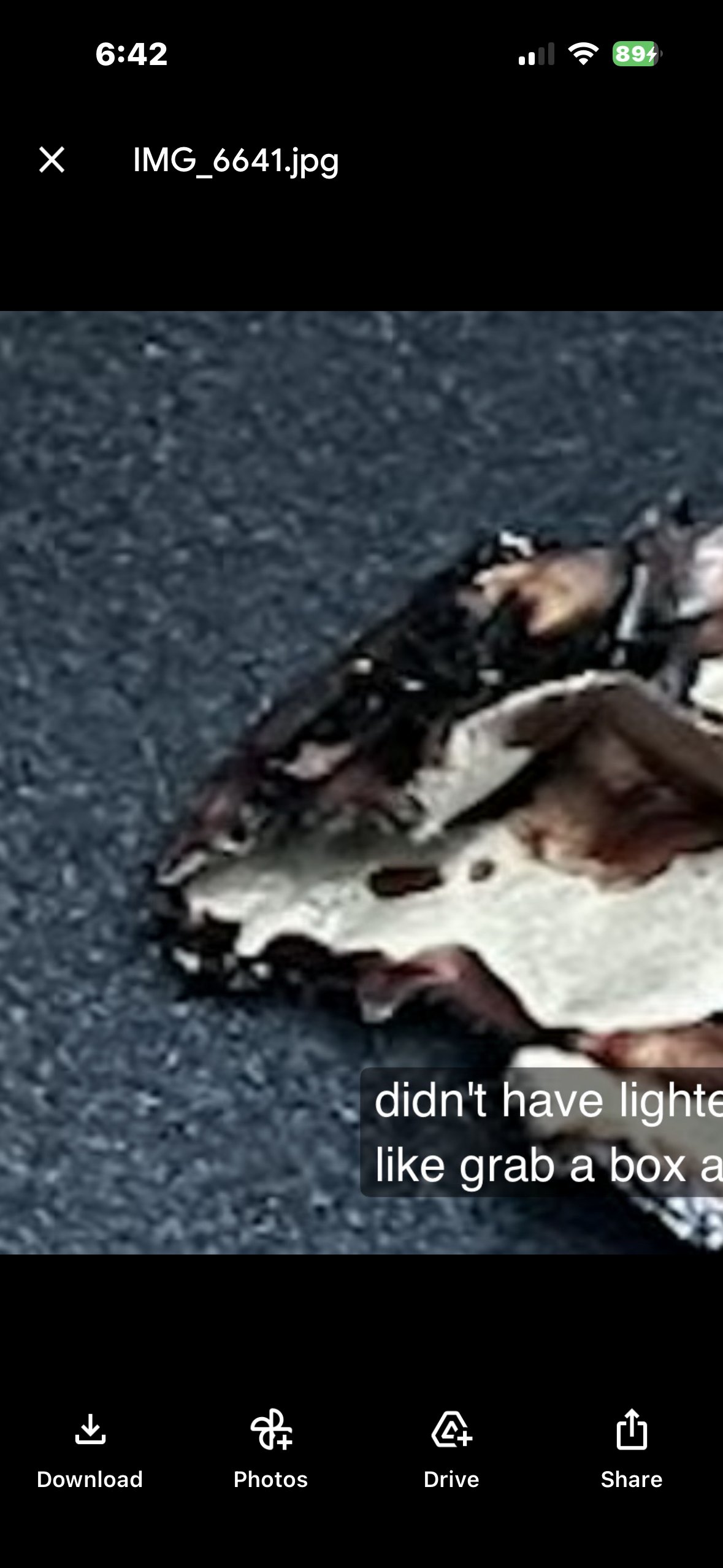 Phone screenshot of IMG_6641.jpg showing the burnt object on dark upholstery